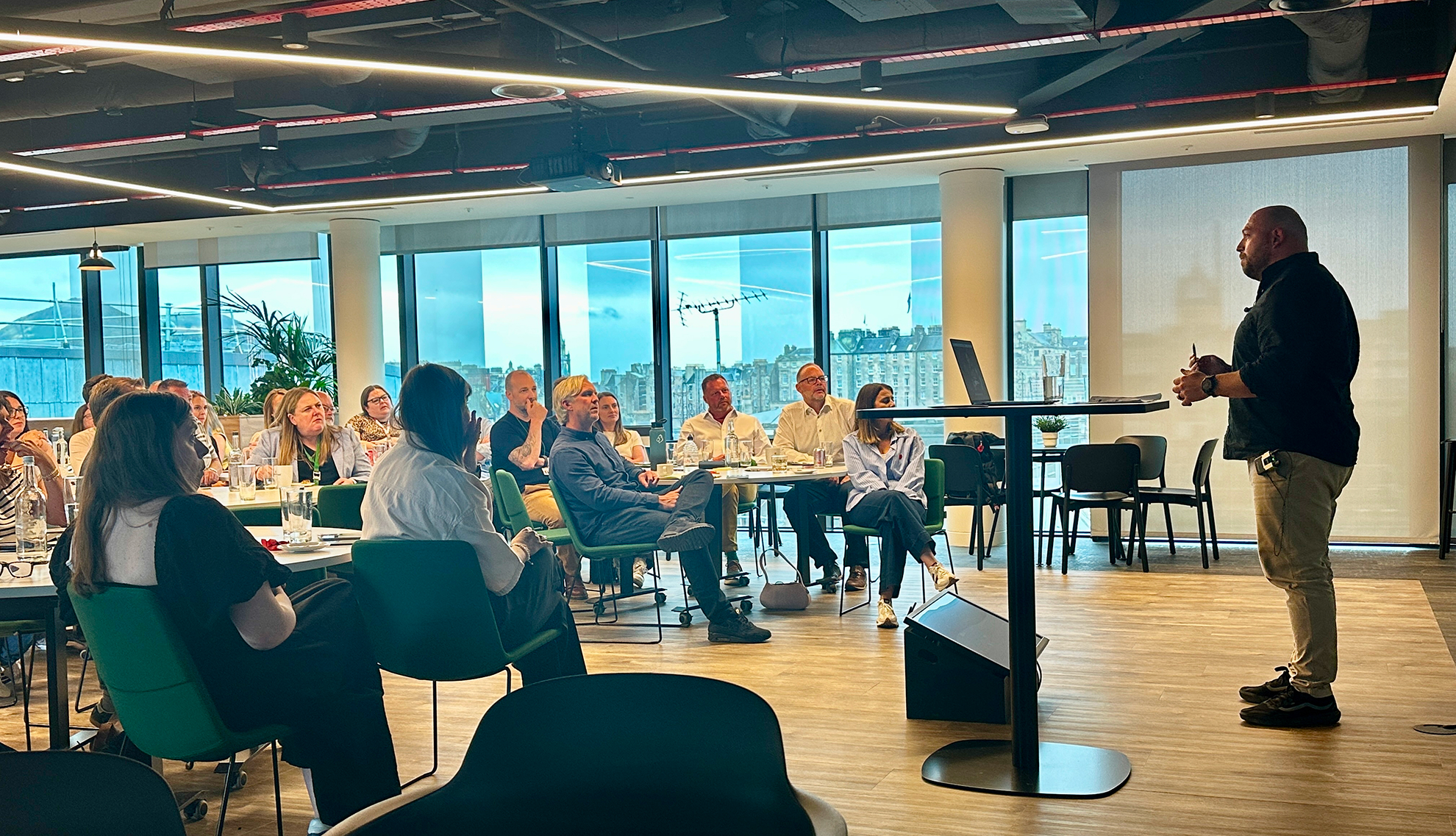 Greg Bateman speaking to an audience at a company event