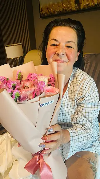 Woman smiling with flower bouquet

