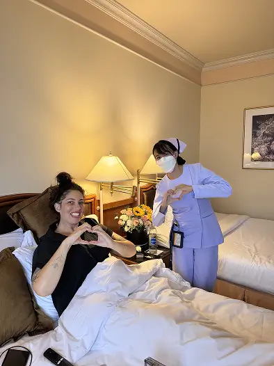 Nurse attending patient in hotel bed
