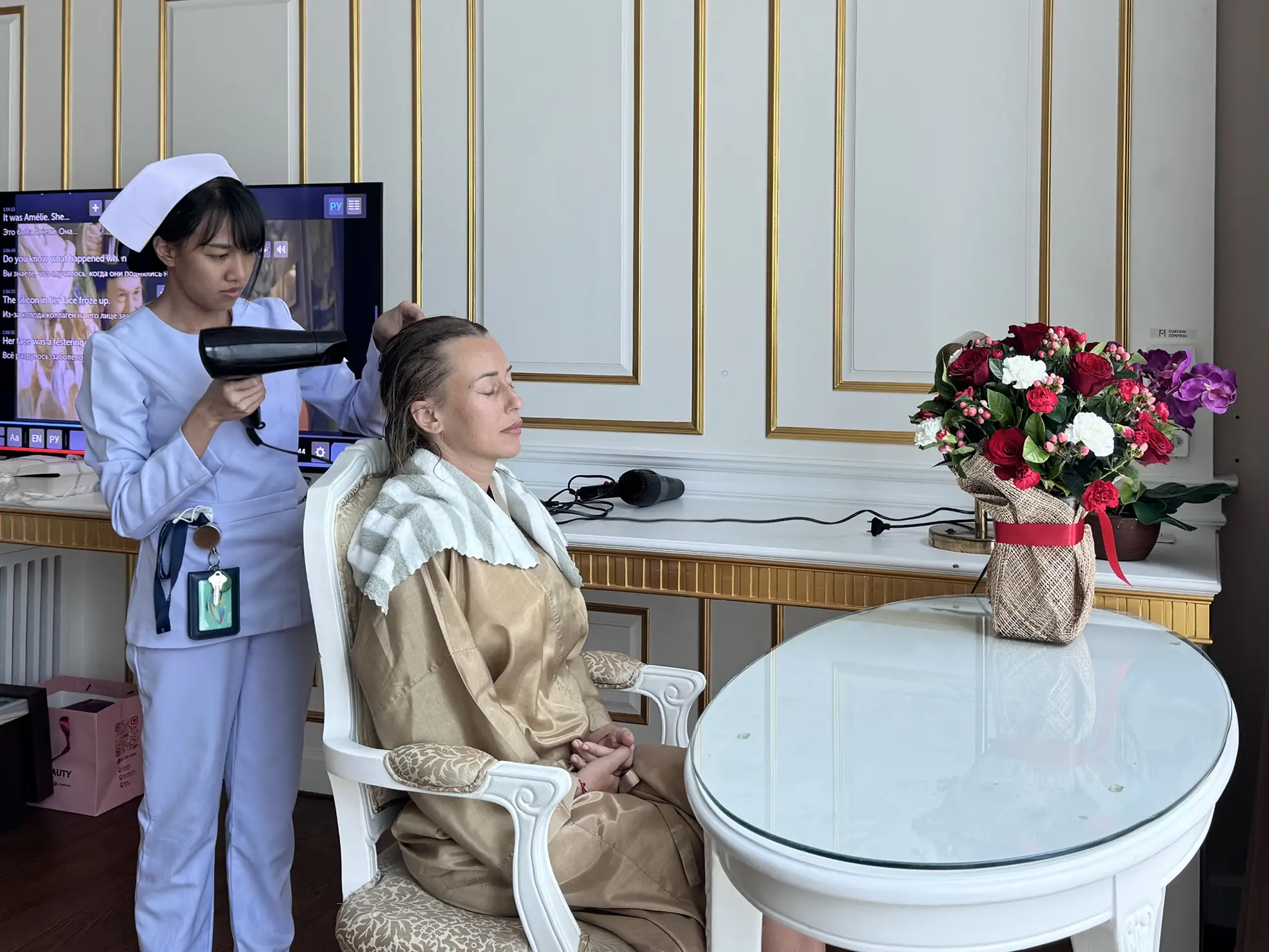 Client in golden robe receiving hair treatment in hotel.

