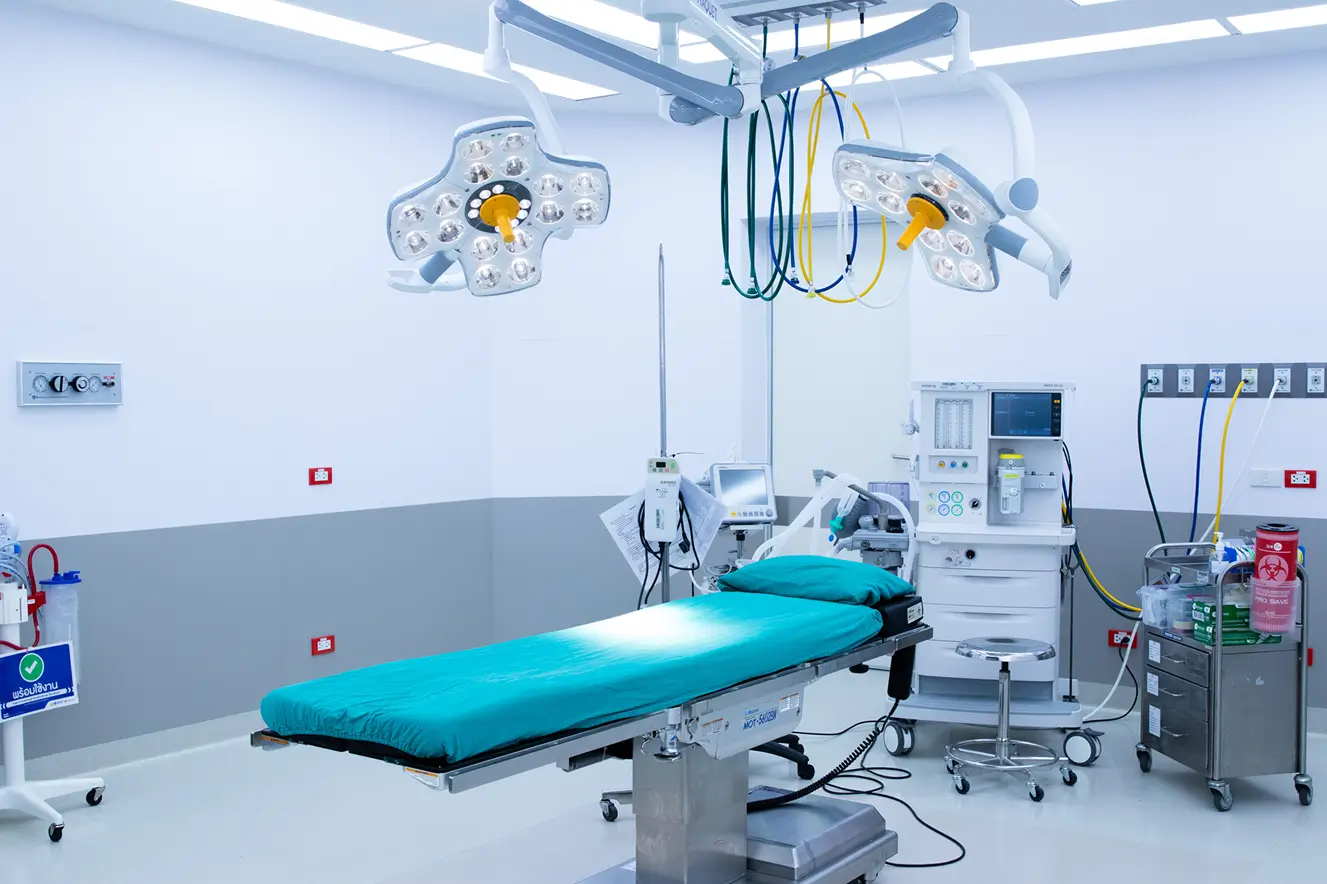 Sterile surgery room with advanced lights, equipment, and teal operating table.