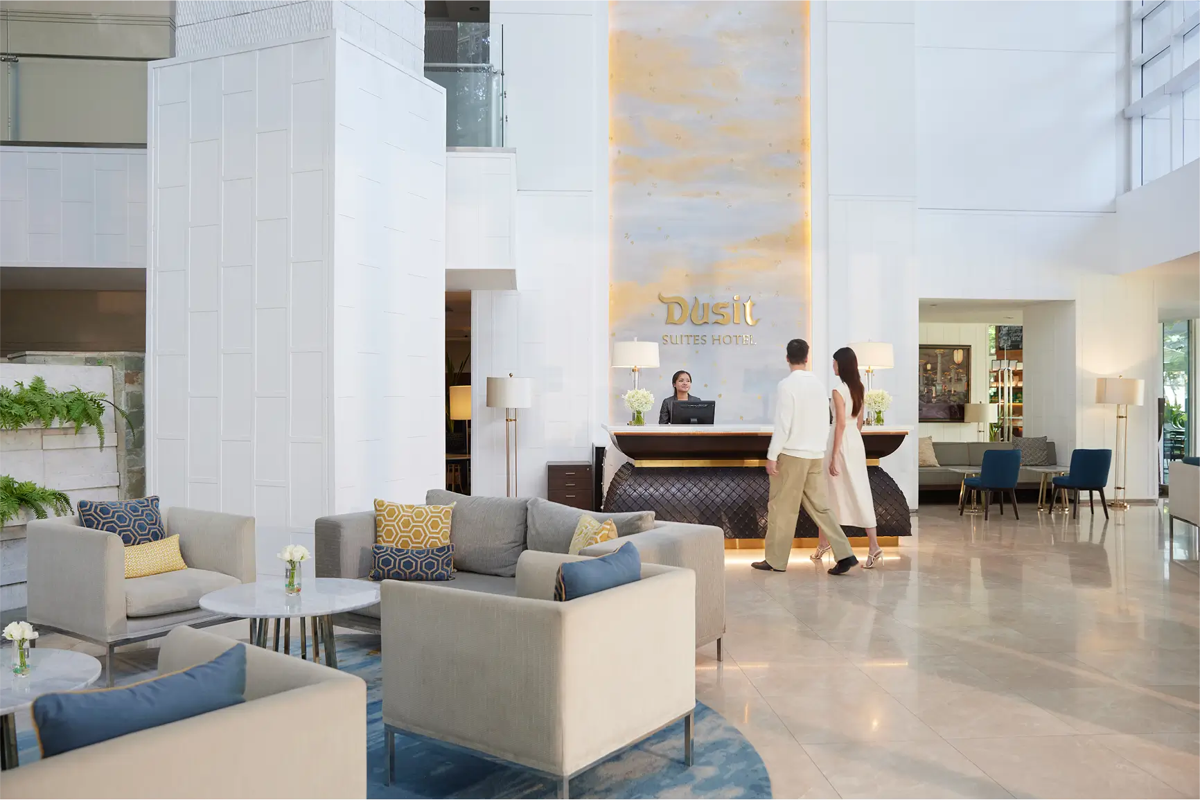 Hotel lobby with guests checking in at the Dusit Suites reception.