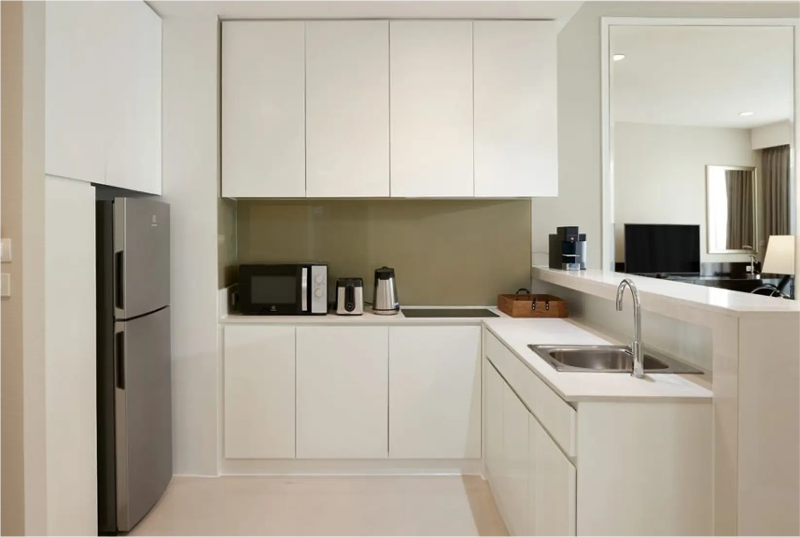 Modern white kitchen with built-in appliances and minimalist design.