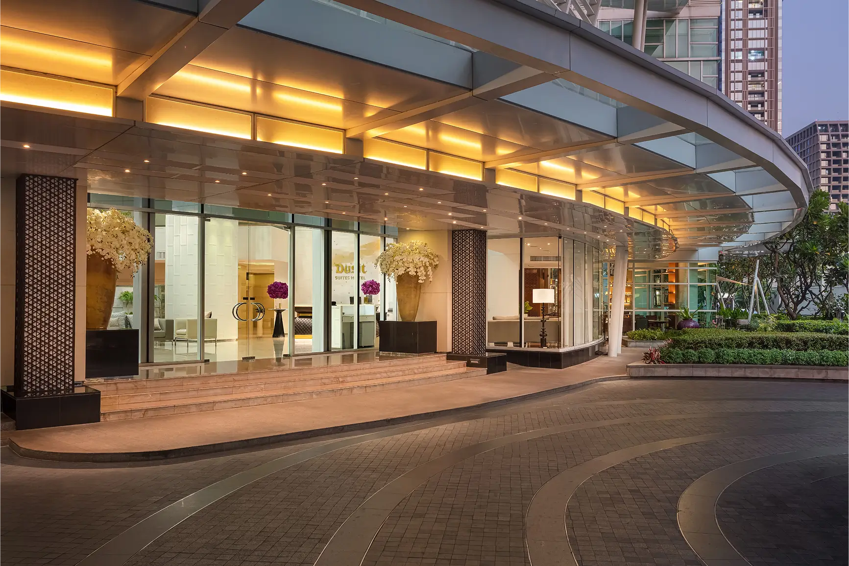 Elegant hotel entrance with glass facade and warm lighting.