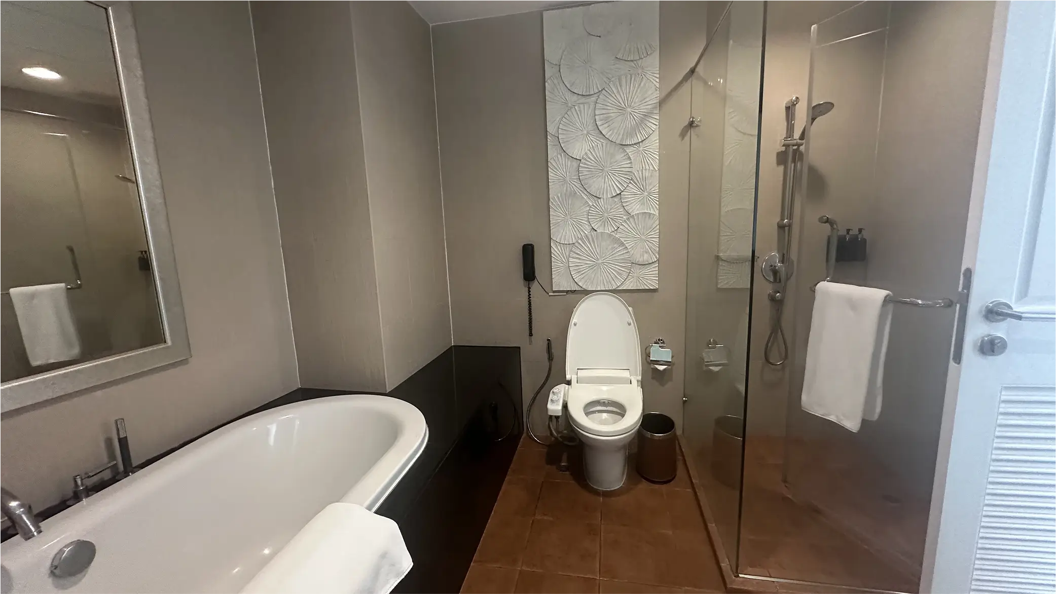 Modern bathroom with bathtub, shower, and decorative wall art.