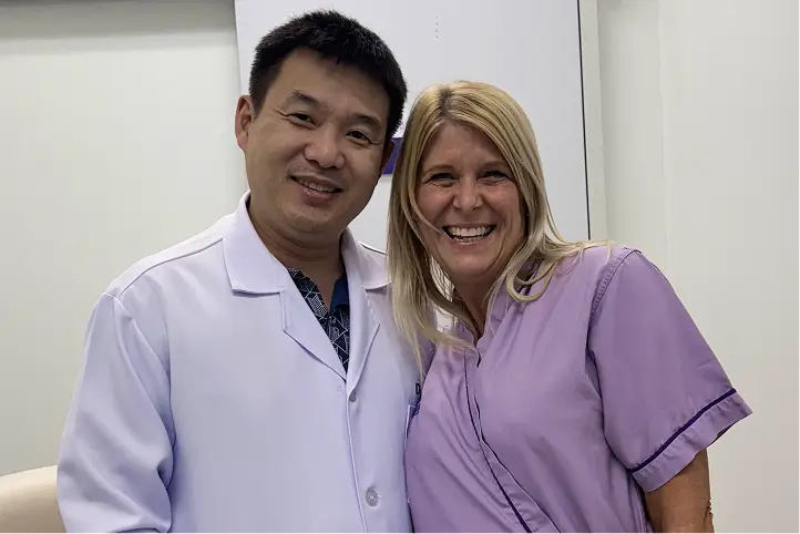 Doctor and patient smiling together in a medical office.