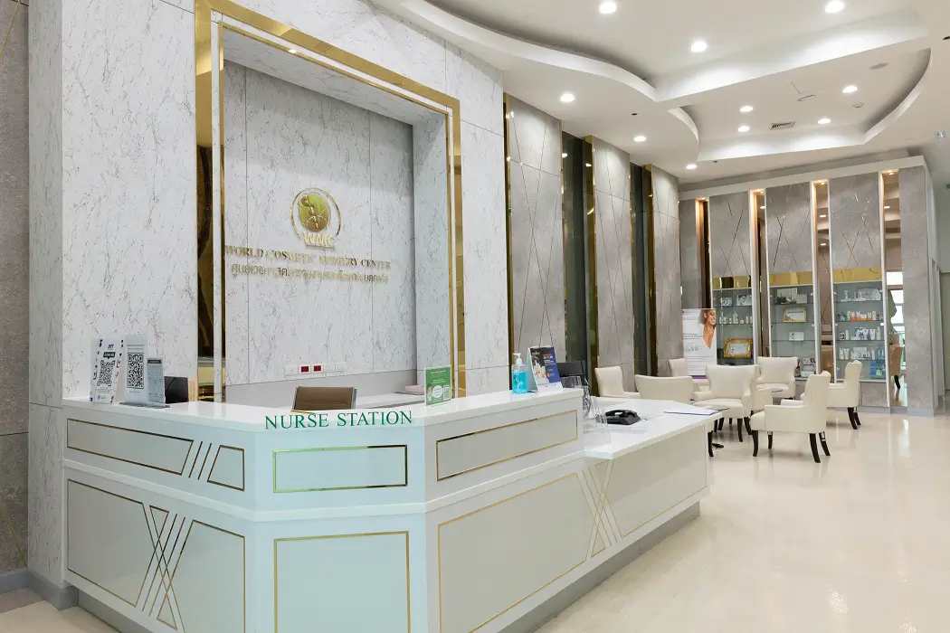 Modern nurse station with white and gold accents in a clean medical office reception area with seating and product displays.