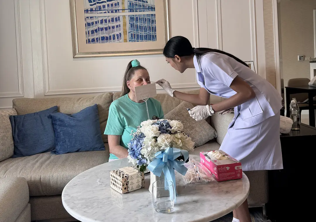 Nurse treating a patient's cheek during a daily in-suite aftercare visit