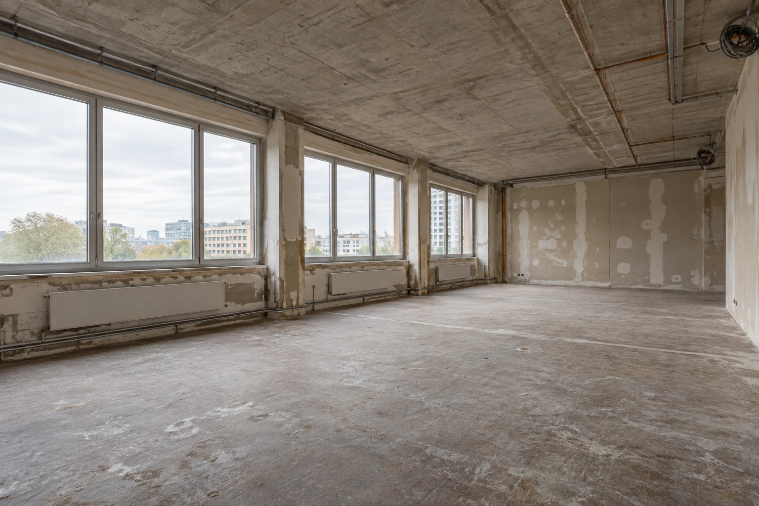Leerer Bürobestand vor dem Trockenbauausbau mit Rohdecke und alten Installationswegen