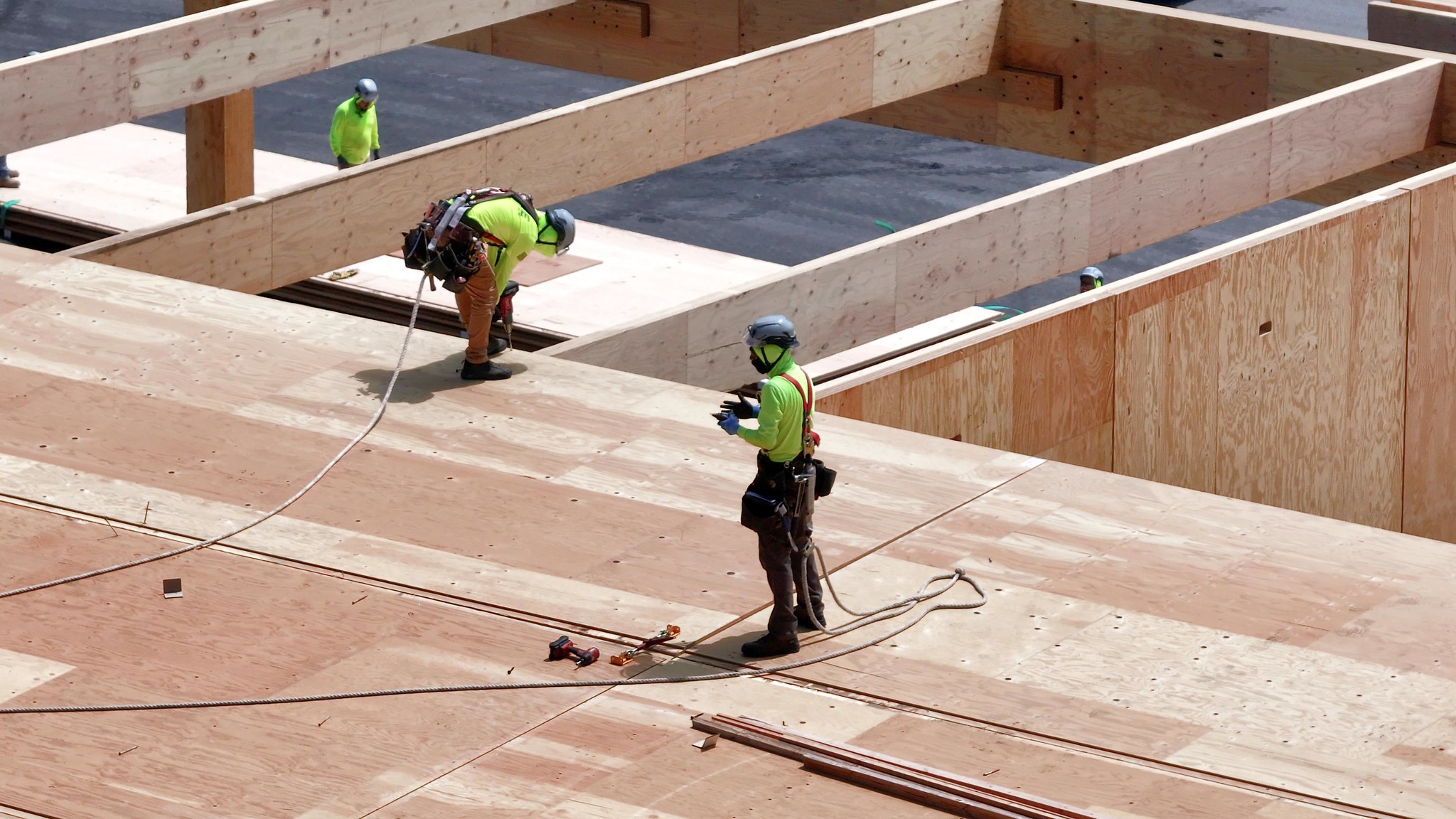 A long truck is parked alongside many pallets of packaged wood. A healthy Maine forest is in the background.