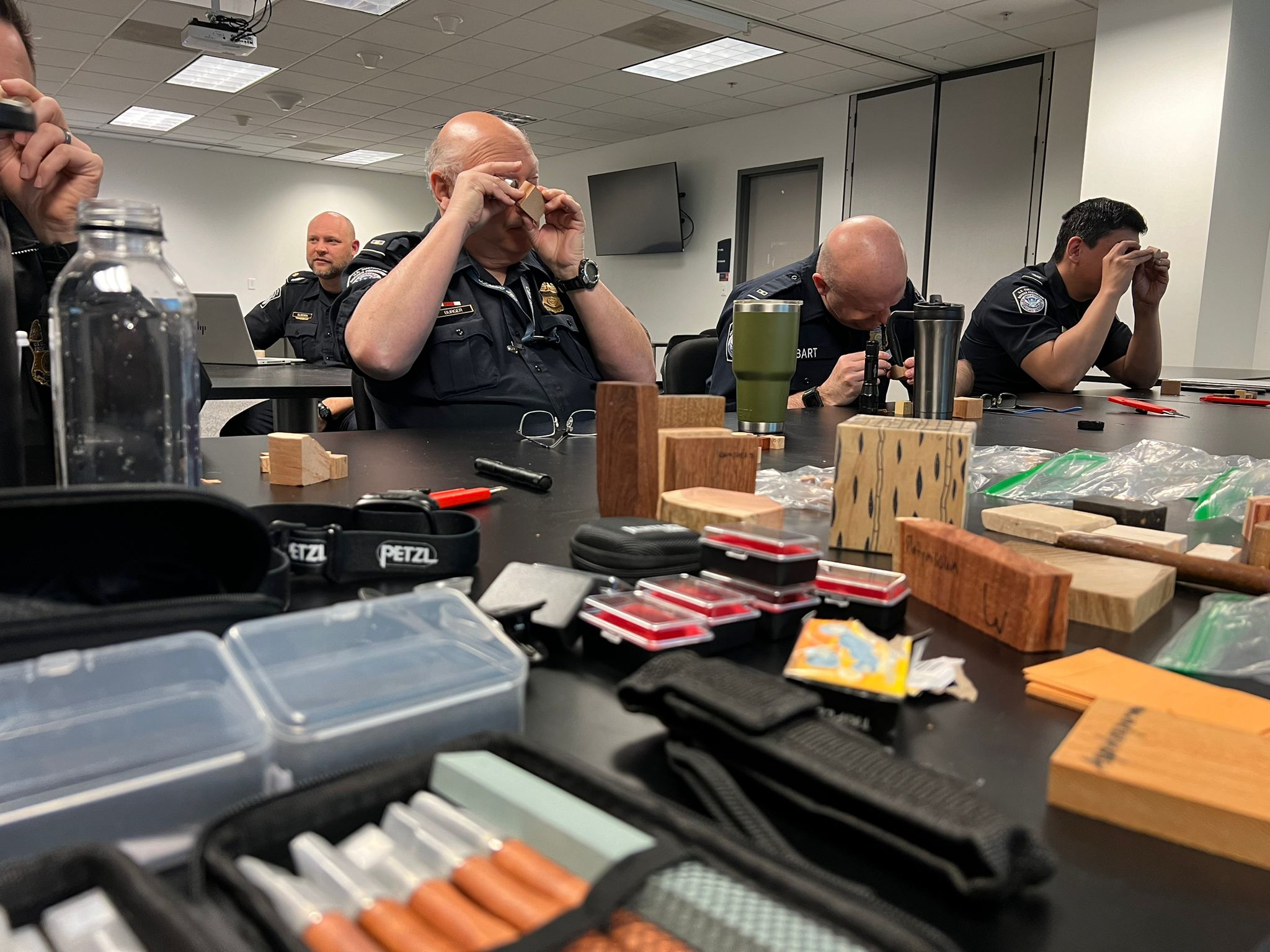 A long truck is parked alongside many pallets of packaged wood. A healthy Maine forest is in the background.