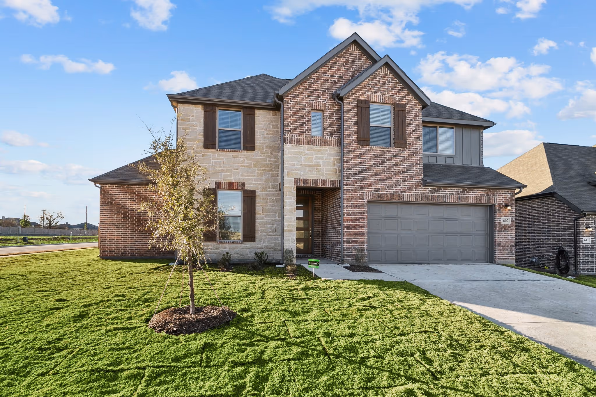 Real image of brick two story house in daylight with driveway