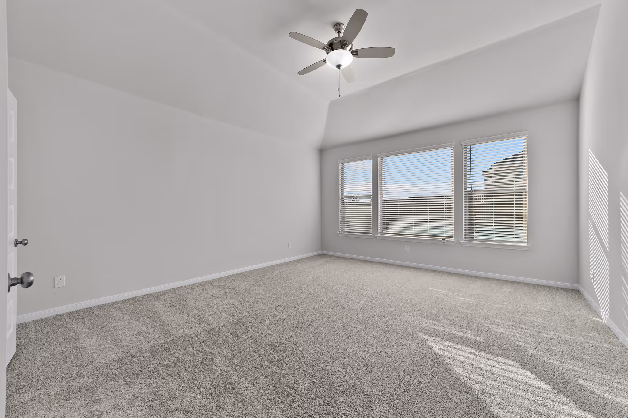 Owners suite with carpet flooring and windows/ceiling fan