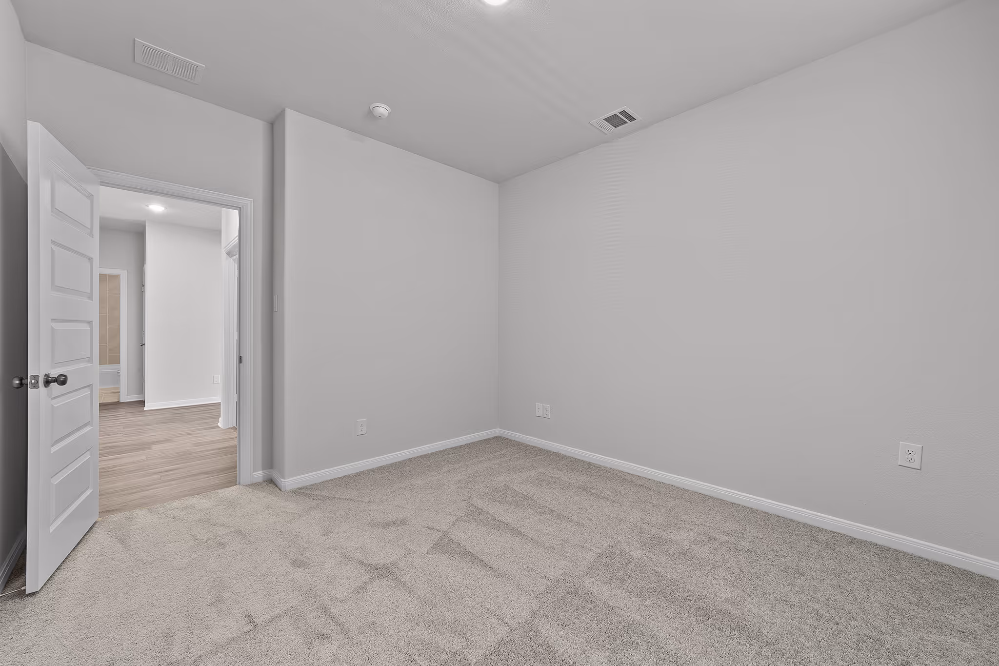 bedroom shot with carpet showing the entry door
