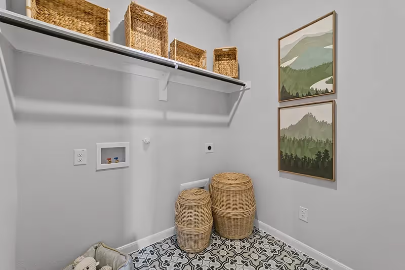 laundry room with clothing rod and patterned tile