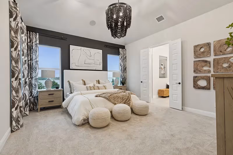 master bedroom with carpet and white walls, 2 windows looking out to the lake
