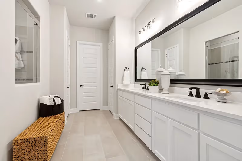 master bath with 2 sinks and white tile/cabinets
