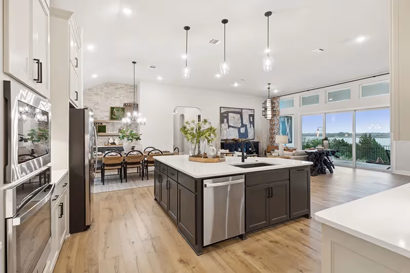 kitchen with angled island and white cabinets that opens to living and dining area