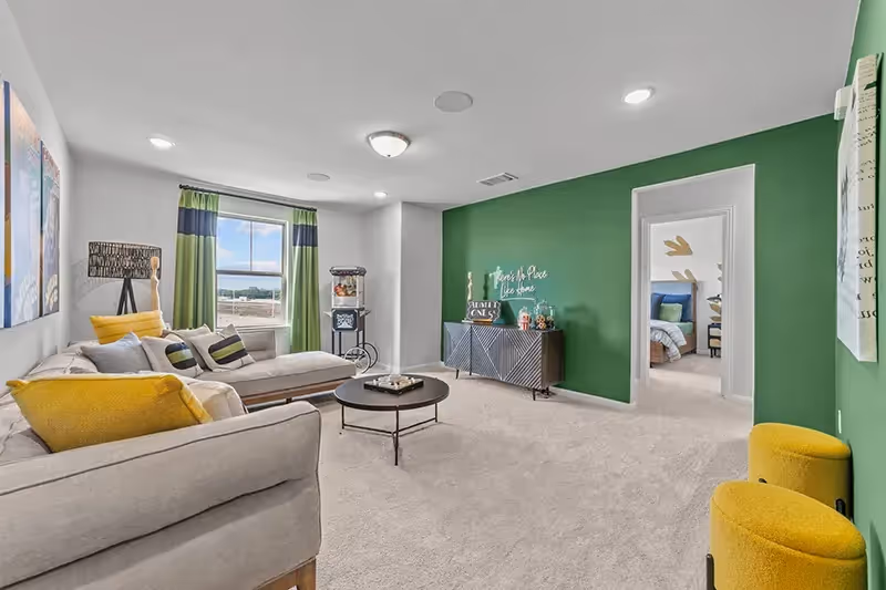 upstairs game room with carpet and painted green walls
