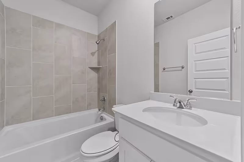 bathroom with shower and white countertops