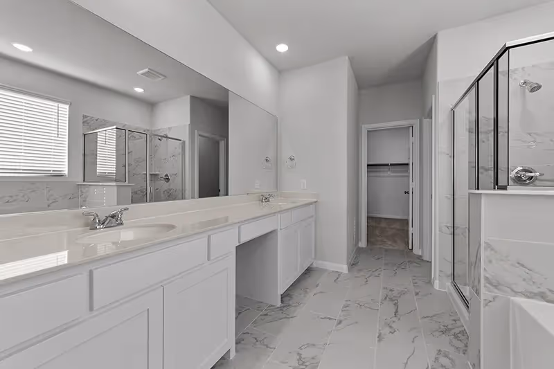 owners bath with light colored tile and walk in shower