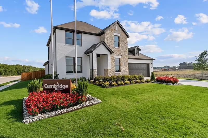 Van Alstyne Tinsley Meadows Community Model Home with painted white brick. A Cambridge Homes sign is in the front lawn