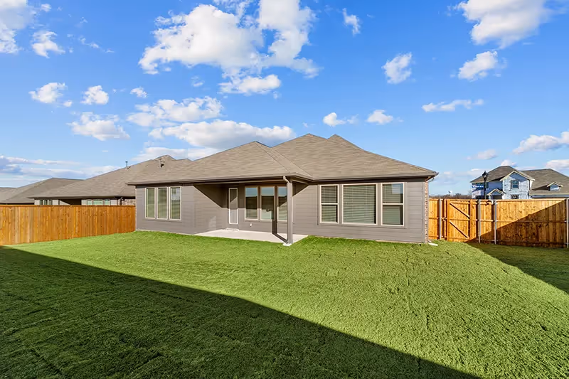 grassy backyard and view of house