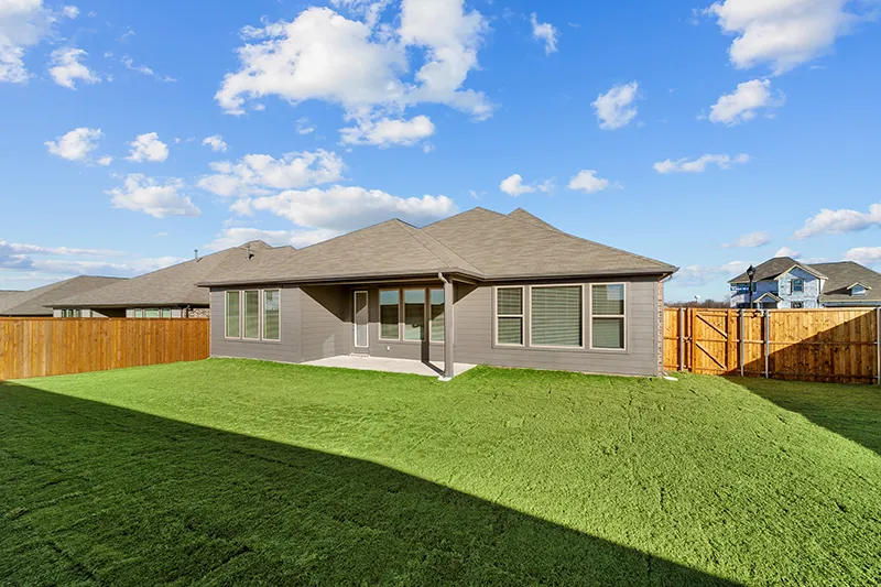 grassy backyard and view of house