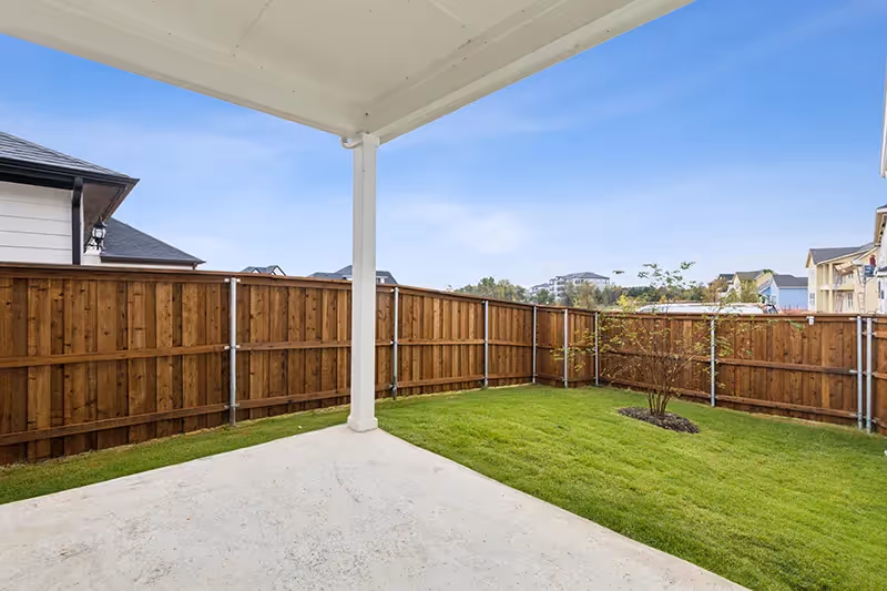 covered patio and grassy backyard