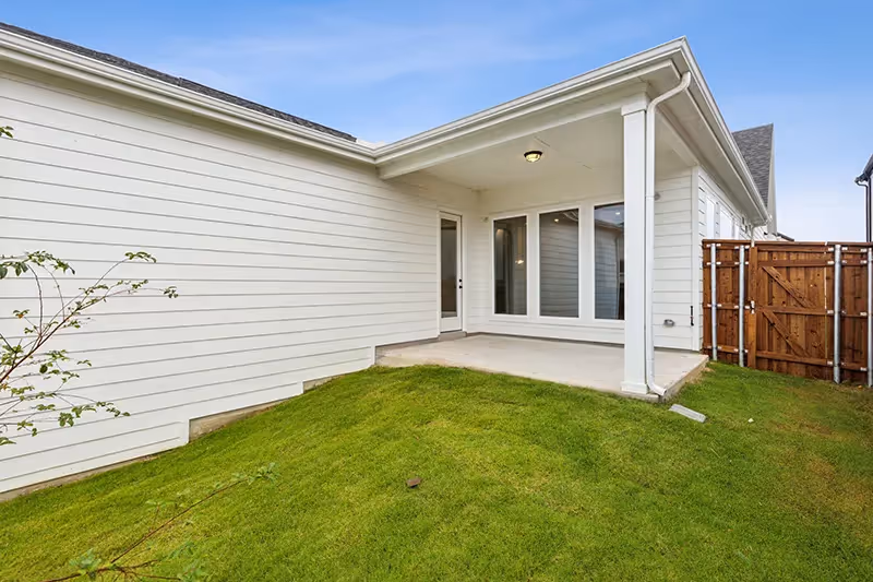 covered patio and grassy backyard