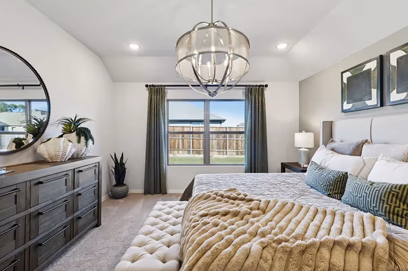 owners bedroom with large windows and chandelier