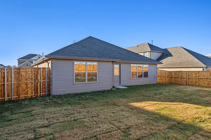 back view of house and grassy backyard