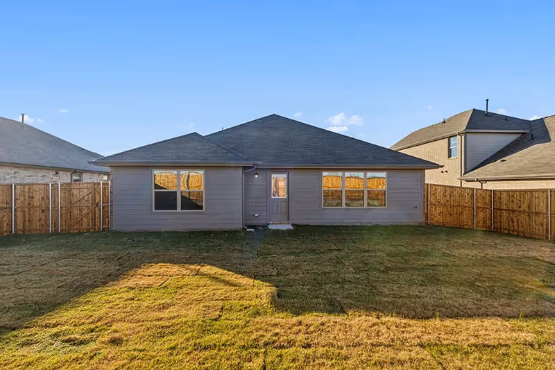 back view of house and grassy backyard