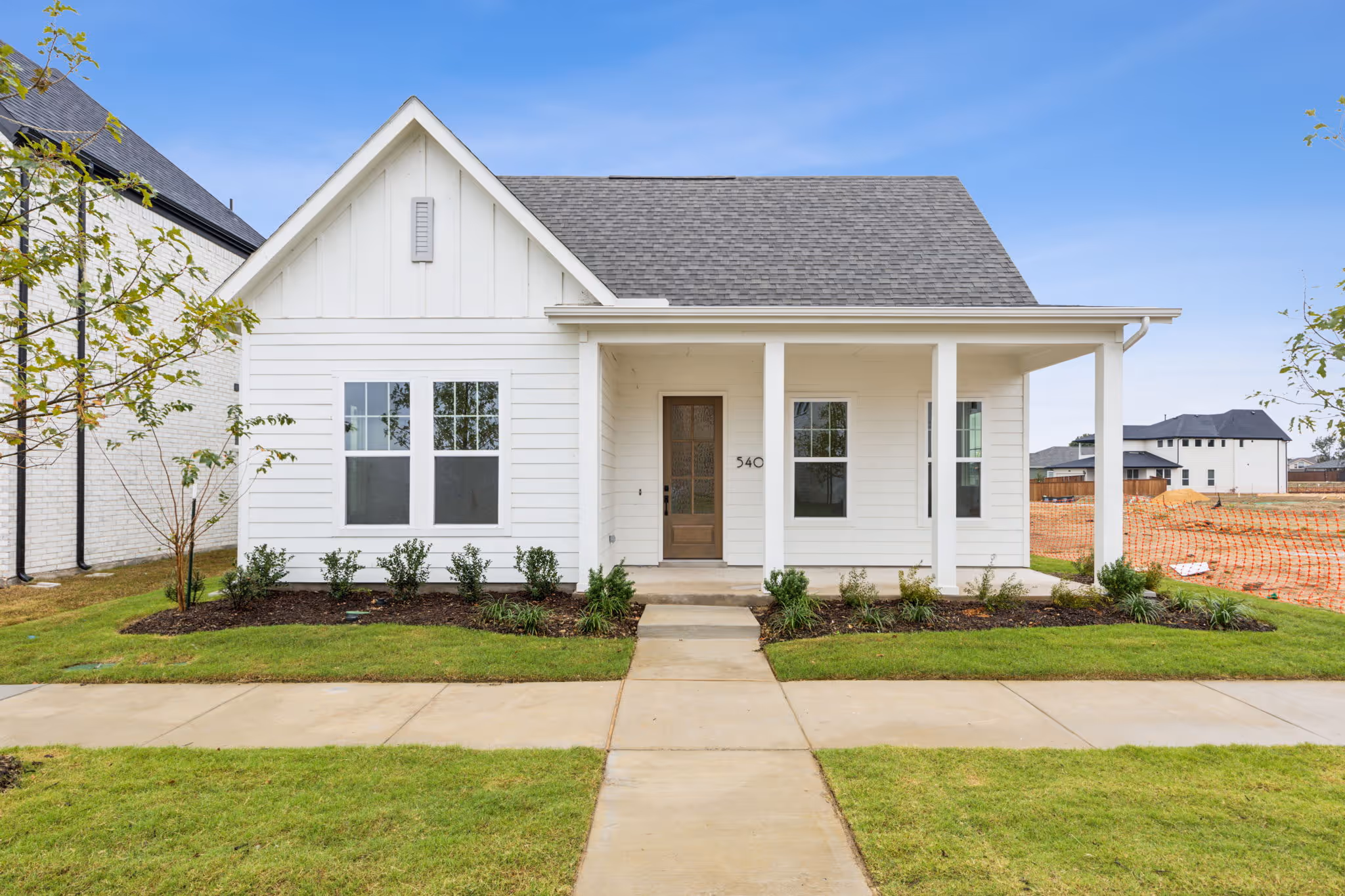 exterior rendering of one story logan floorplan, which is white siding with dark entry door