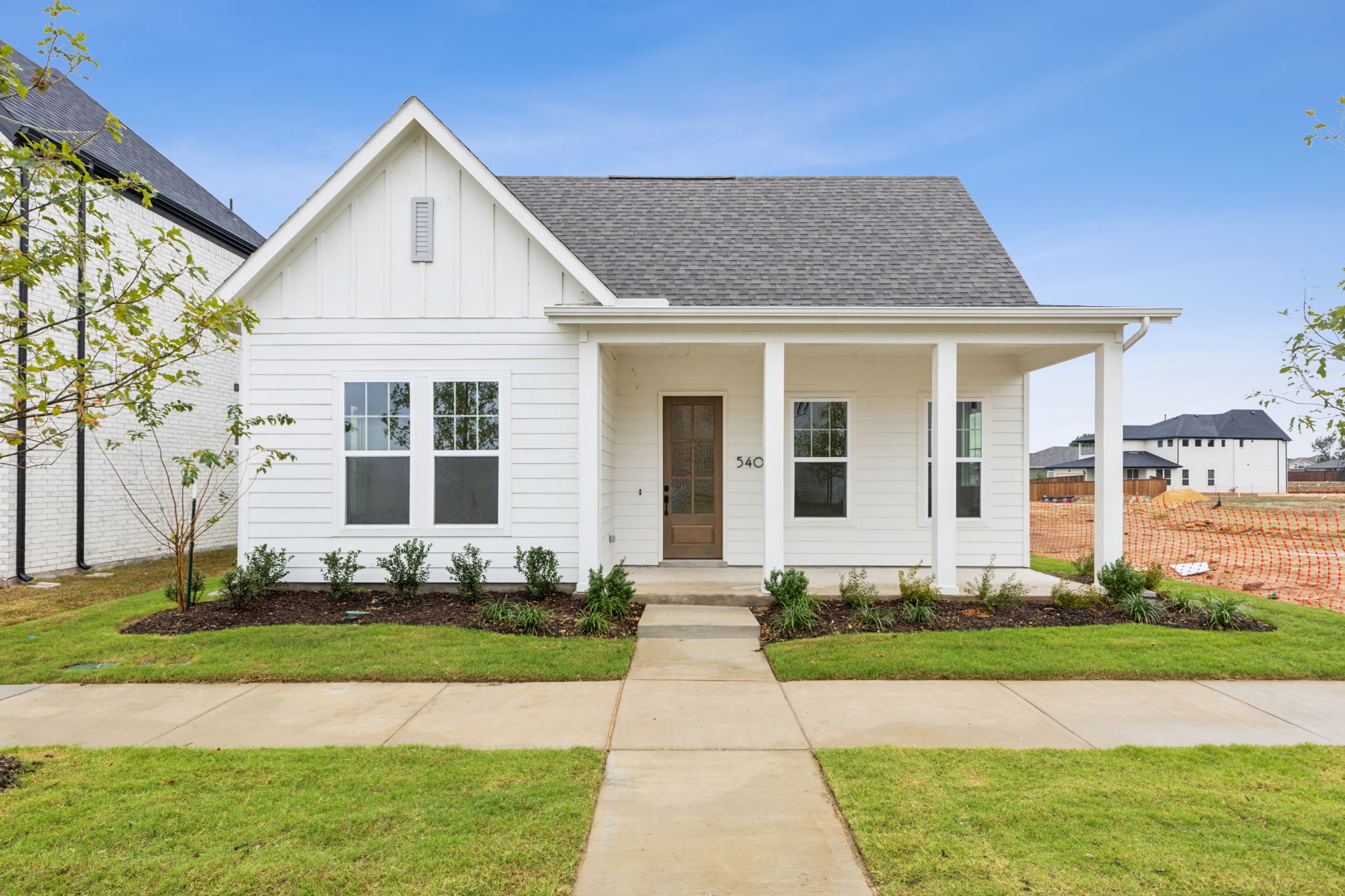 exterior rendering of one story logan floorplan, which is white siding with dark entry door
