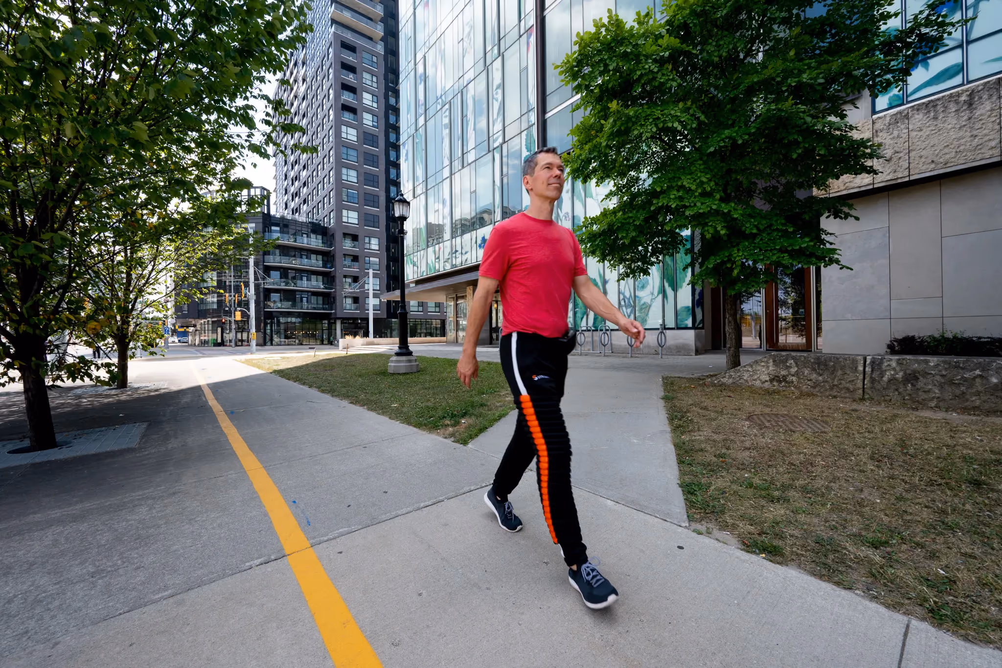 Man in Strivonix python pants walking on a sidewalk