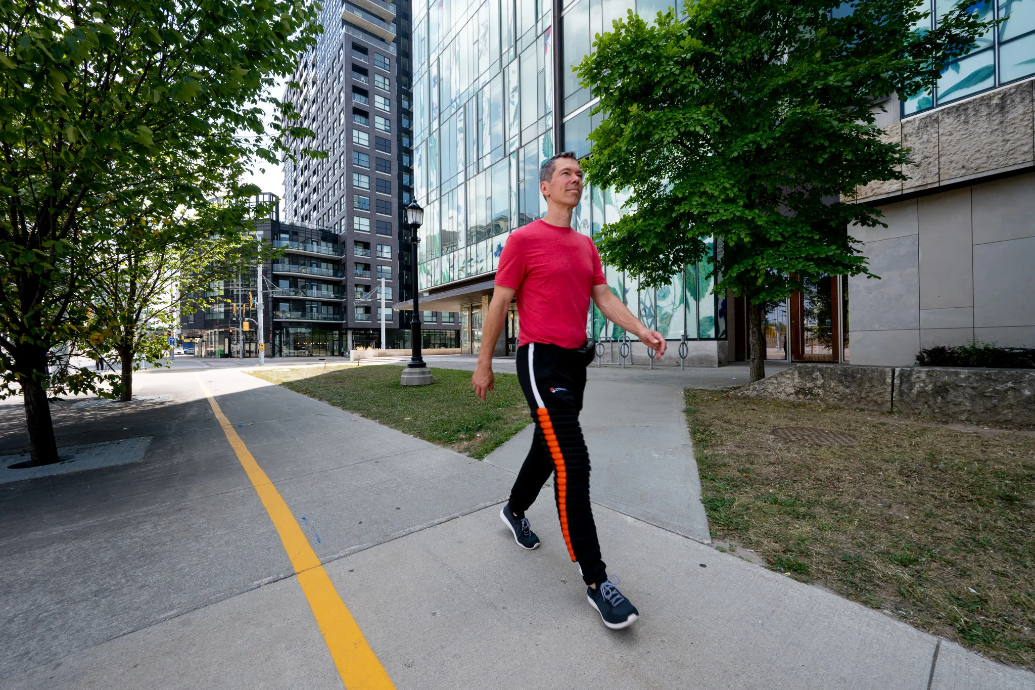 Man in Strivonix python pants walking on a sidewalk