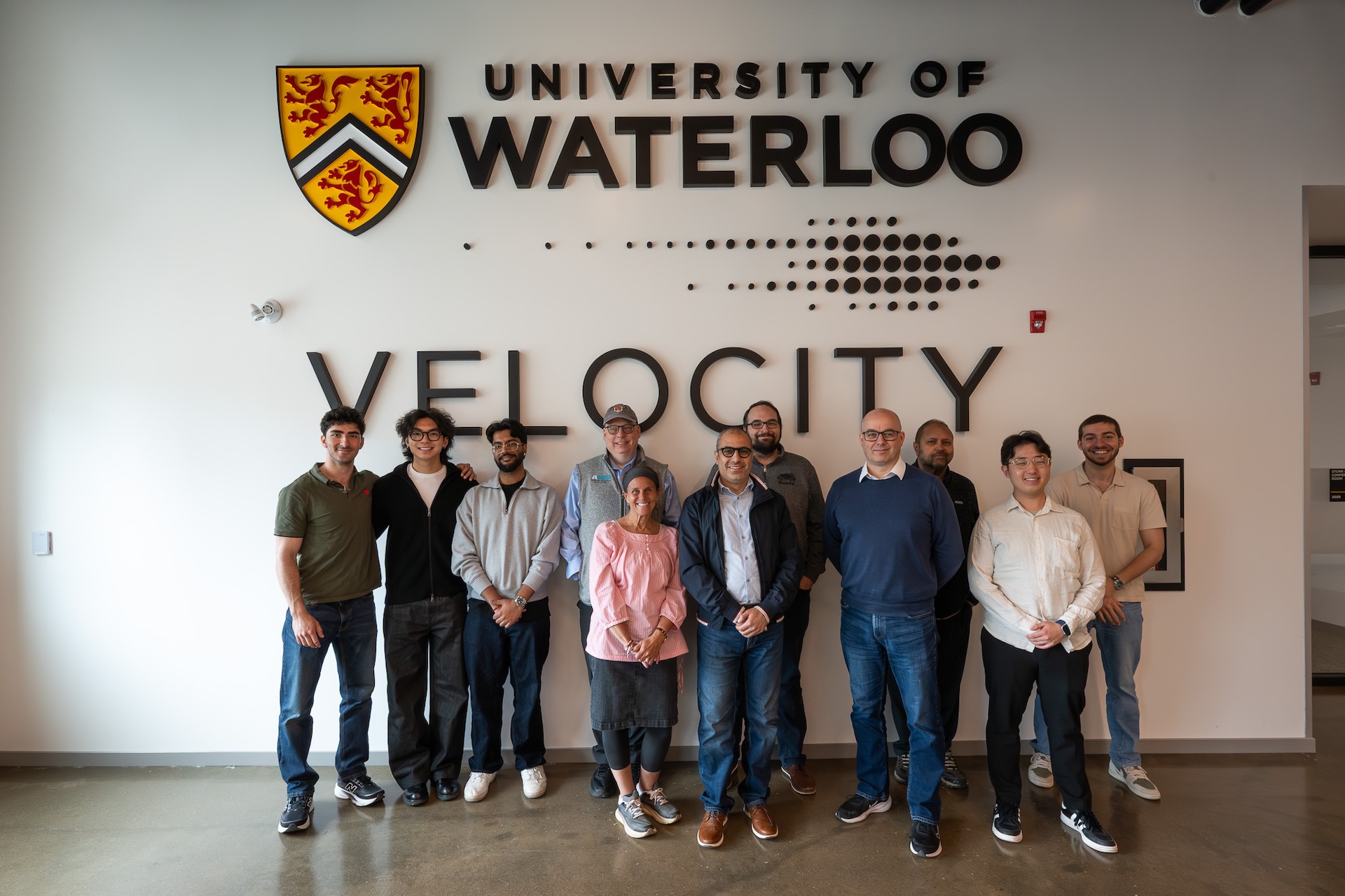 Founders standing in front of the Velocity and University of Waterloo logo
