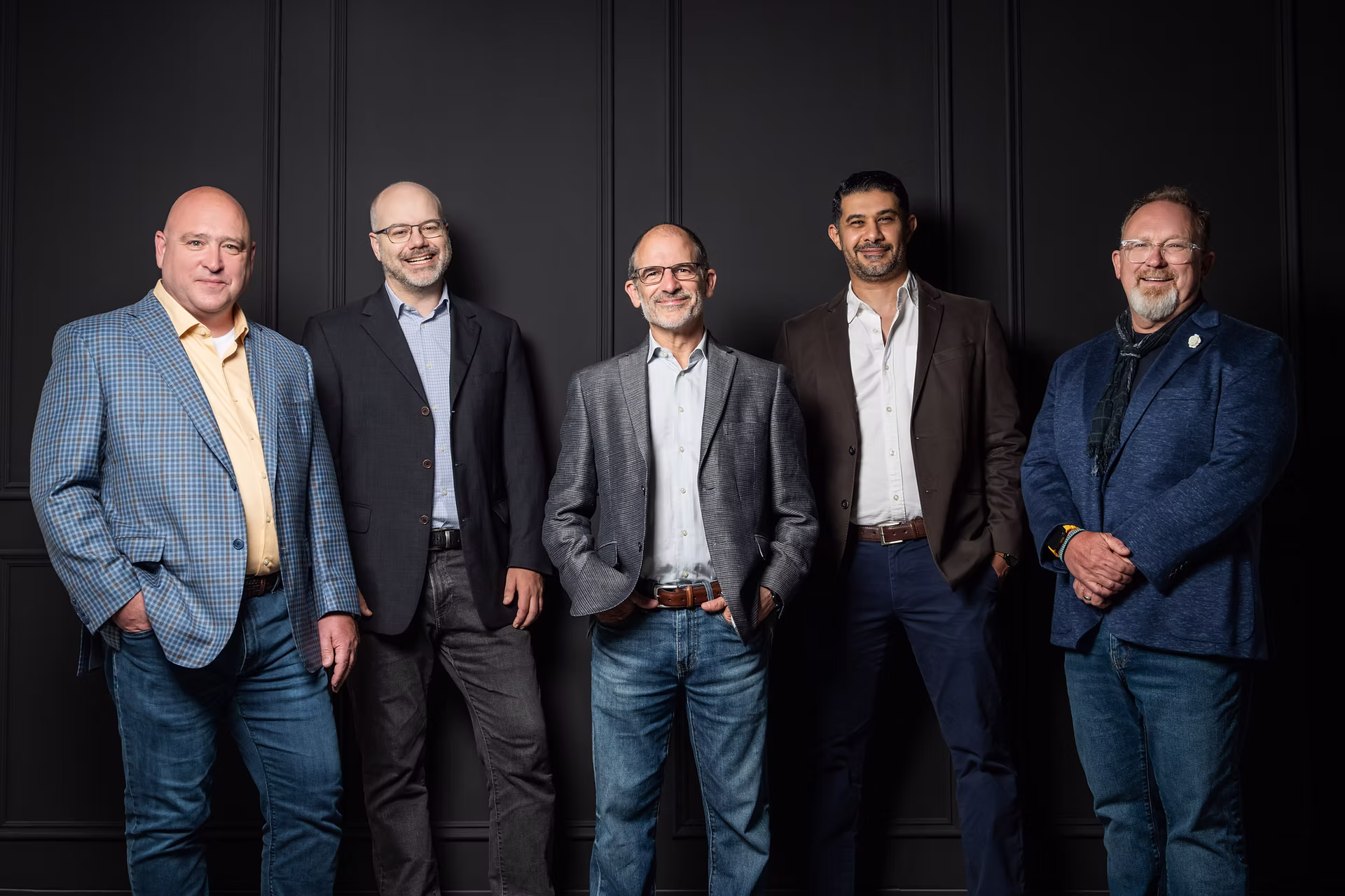 Palitronica's executive team posing in front of a black wall.