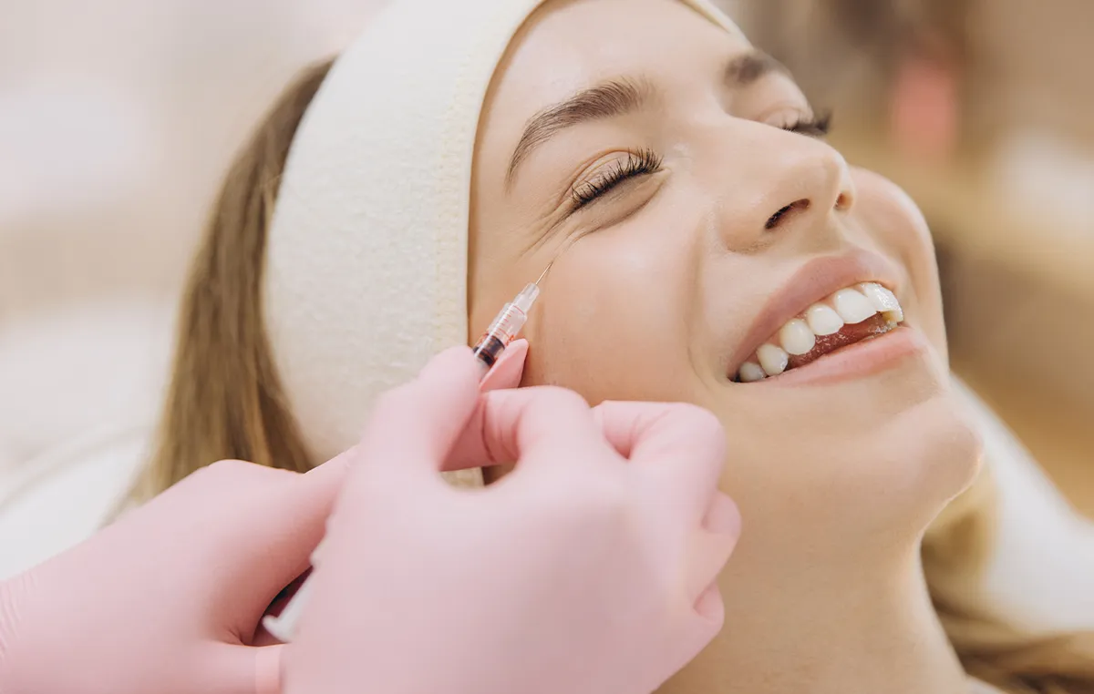 Woman with hair pulled back in a headband reclines in a patient chair and gets Botox injections for frown lines and crow’s feet in East Brunswick, NJ