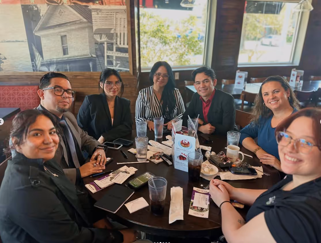 Members of The Osceola Chamber gathered around a table during a networking event.
