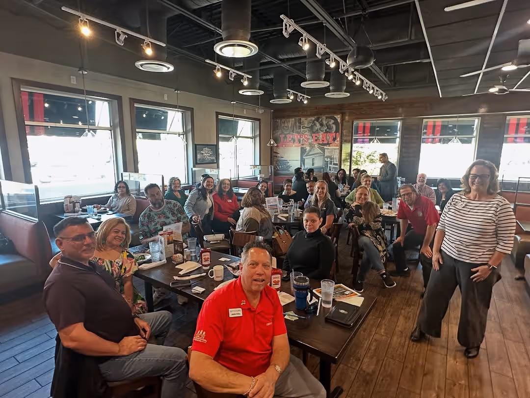 First Friday networking event hosted by The Osceola Chamber, showing local business professionals gathered at a restaurant.