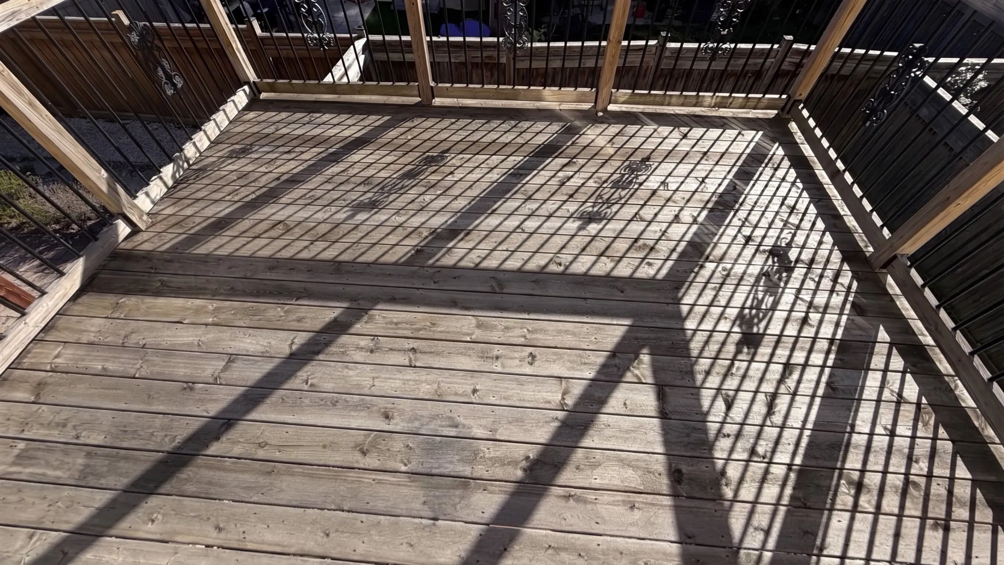 Grey Deck Restored in Maple: Weathered Pressure-Treated Deck Sanded and Stained Dark with an Oil-Based Finish