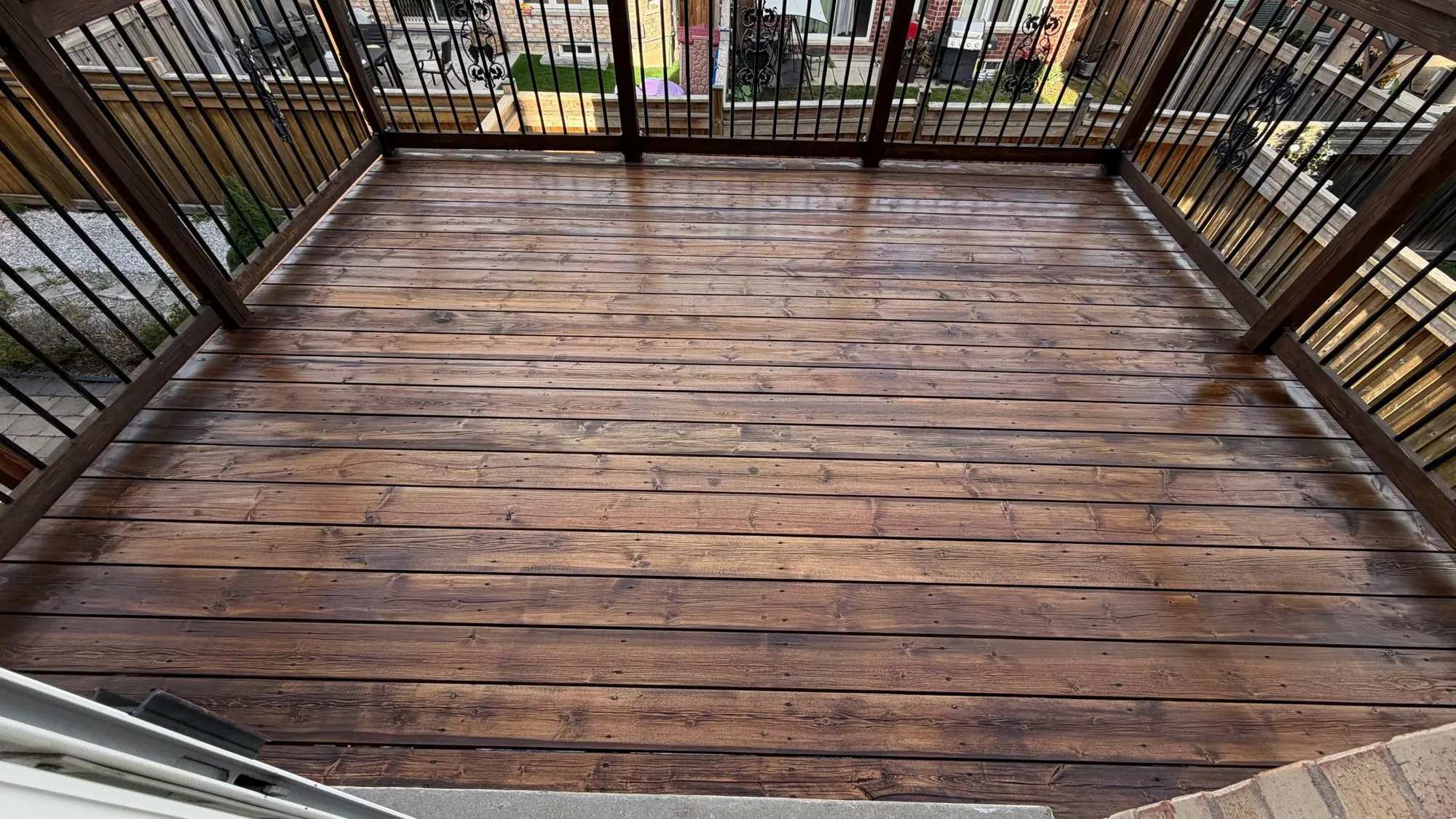 Grey Deck Restored in Maple: Weathered Pressure-Treated Deck Sanded and Stained Dark with an Oil-Based Finish