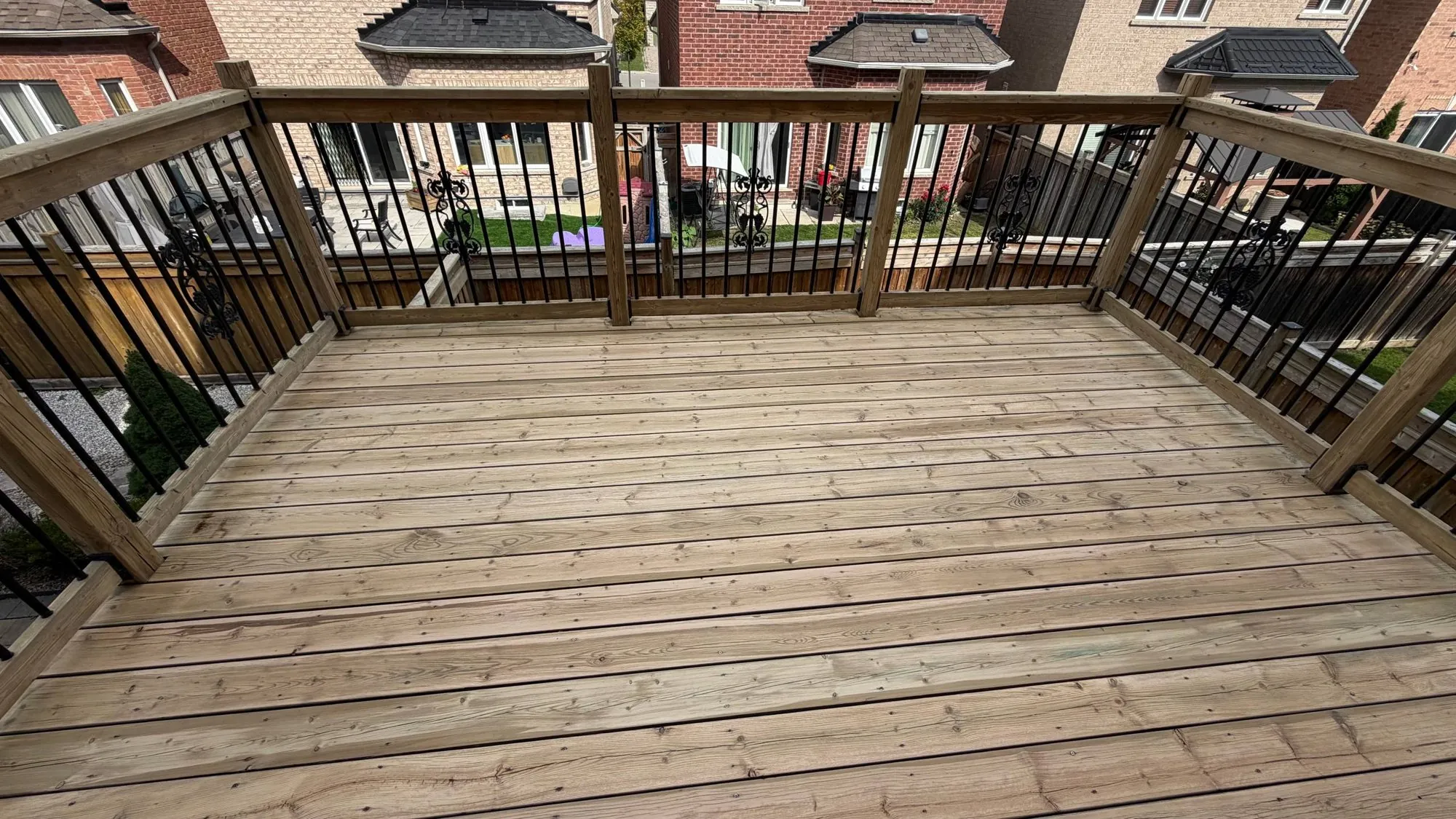 Grey Deck Restored in Maple: Weathered Pressure-Treated Deck Sanded and Stained Dark with an Oil-Based Finish