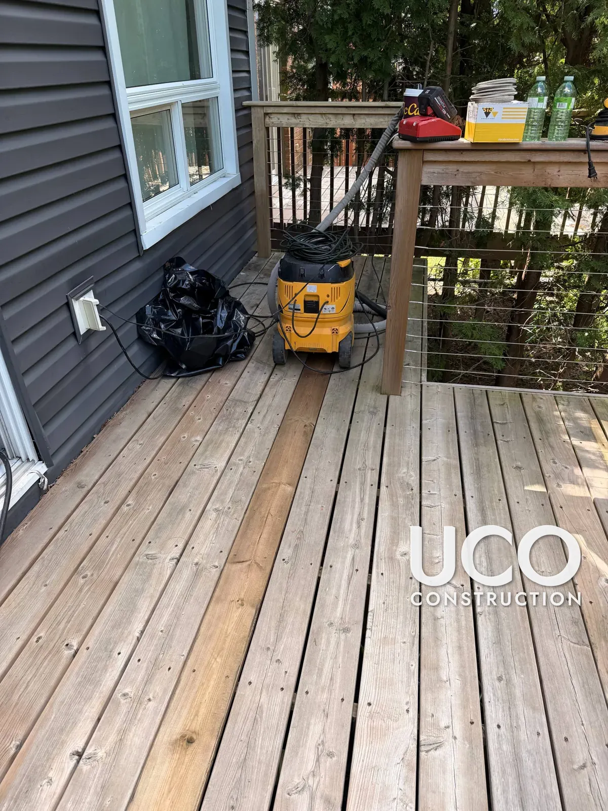Deck Restoration in Oshawa: Grey Cedar Deck with Cable Railings Sanded to Bare Wood, One Board Replaced and Finished with Oil-Based Stain