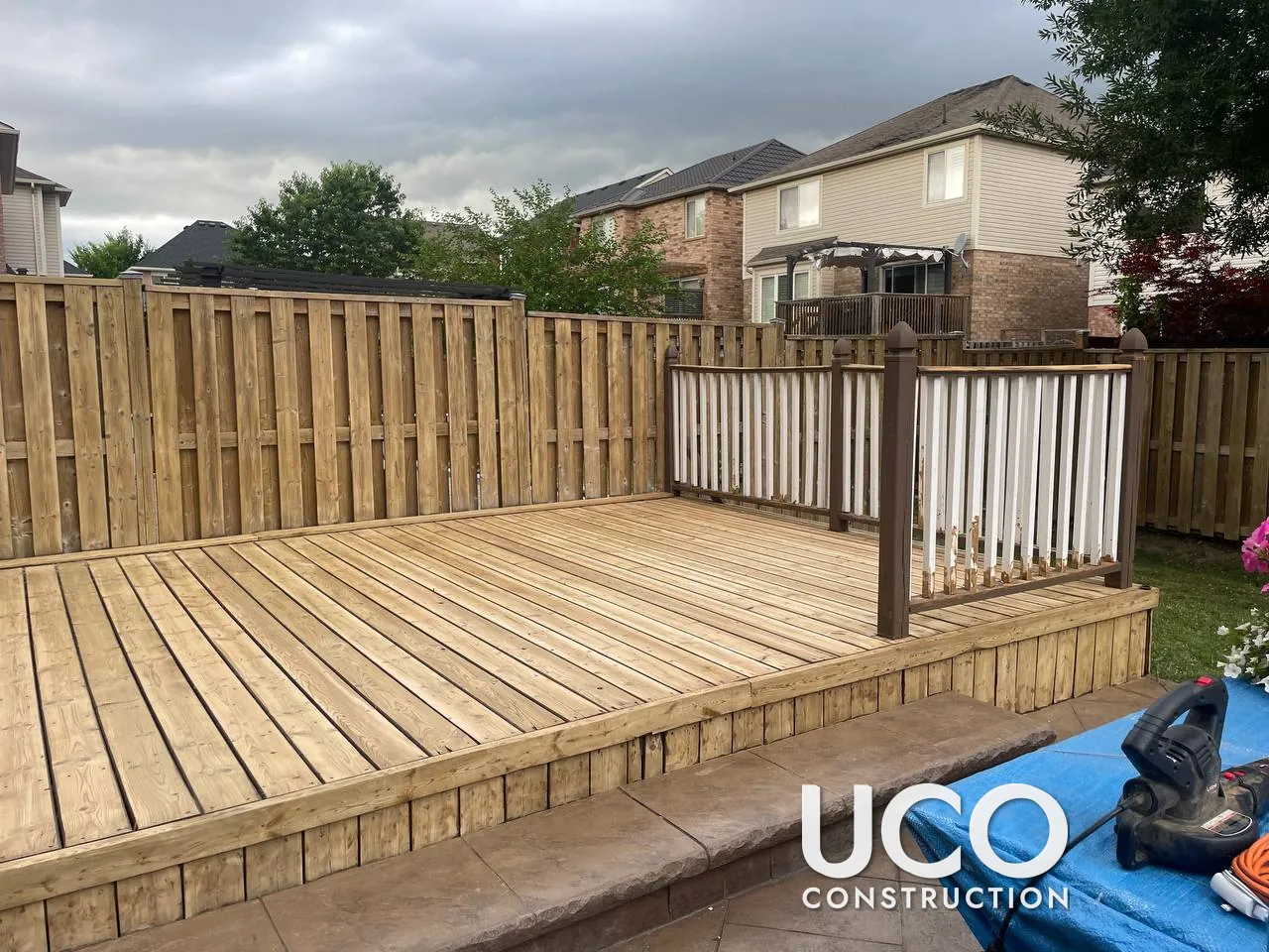 Deck and Fence Staining in Brampton: Faded Brown Deck and Grey Privacy Fence Sanded to Bare Wood and Refinished Together in a Warm Oil-Based Stain, Railings Restained Brown