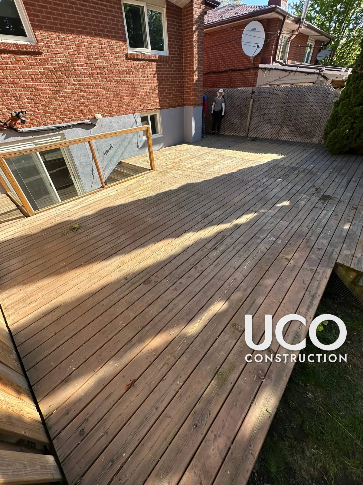 Deck Staining in Etobicoke: Large Weathered Backyard Deck With Glass Railing Sanded and Refinished in a Warm Brown Stain