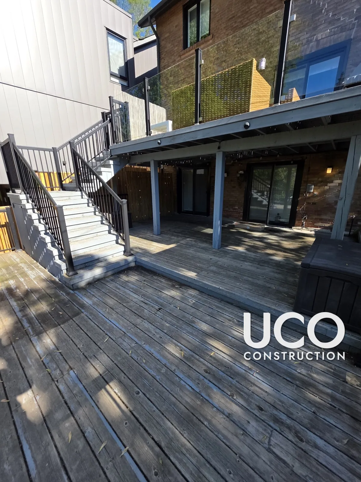 Deck Repair and Staining in Toronto: Rotted Deck Section Under a Balcony Rebuilt With Properly Gapped Boards, Then Sanded and Stained