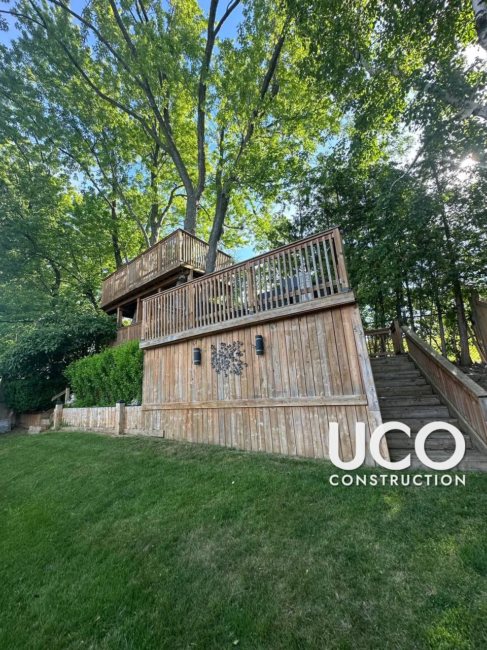 Deck Staining in North York: Multi-Level Deck Built Around Mature Trees, With Tall Board Skirting and Stairs, Cleaned, Sanded and Stained in a Rich Redwood Tone